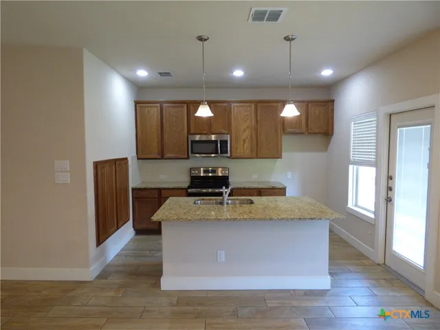 a kitchen with a sink a counter space and wooden floor