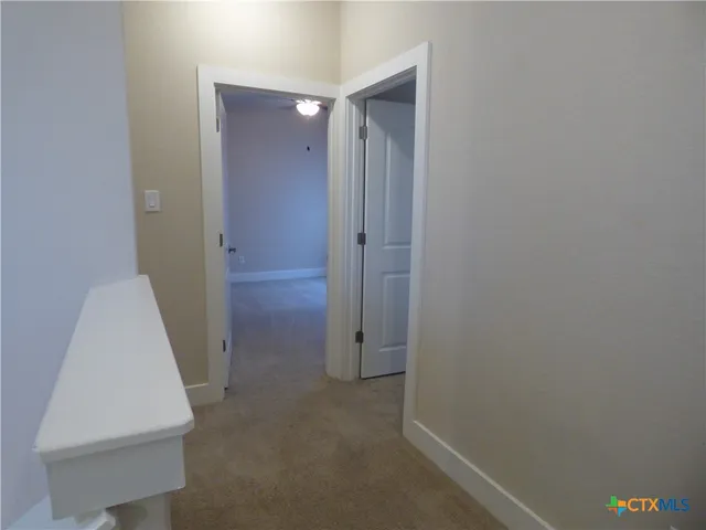 an empty room with a chandelier fan and closet