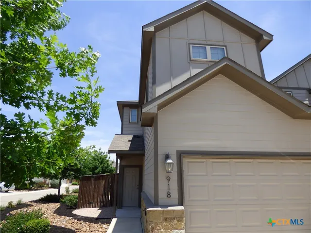 an empty room with a chandelier fan and windows