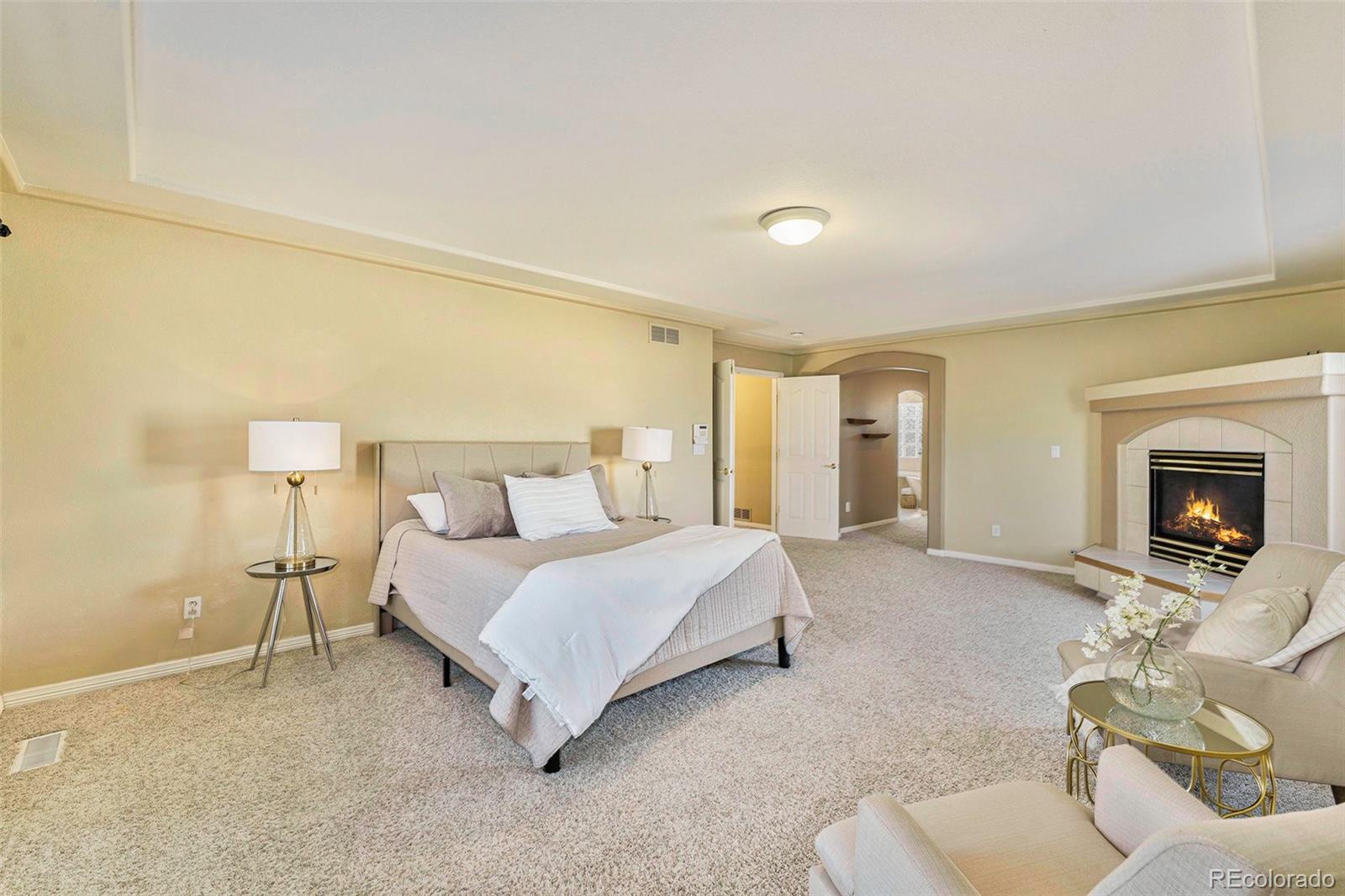 3042 Wyecliff Way Highlands Ranch, CO 80126 - Photo 17 of 40 a spacious bedroom with a bed and a fireplace
