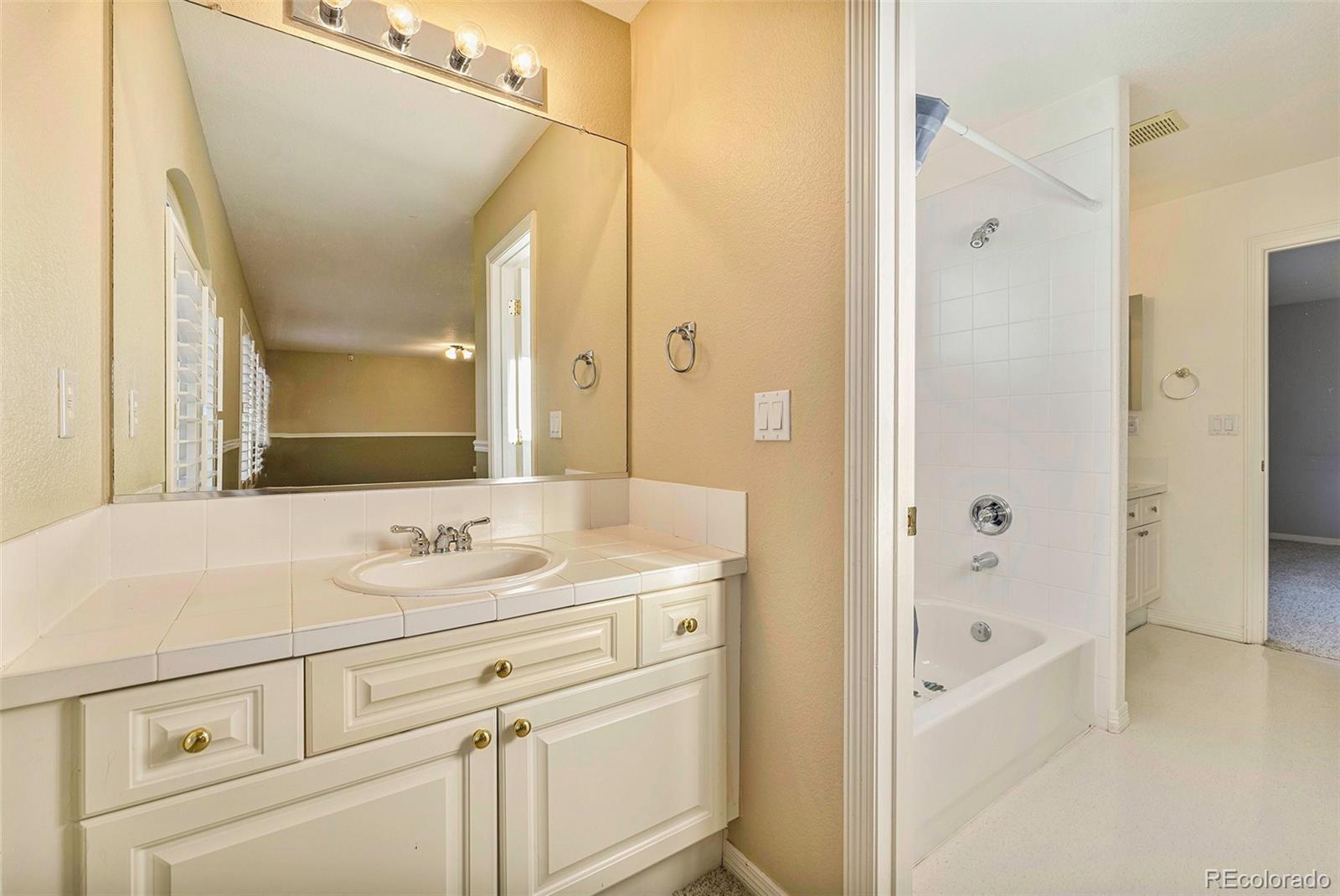 3042 Wyecliff Way Highlands Ranch, CO 80126 - Photo 29 of 40 a bathroom with a sink a mirror and a bathtub