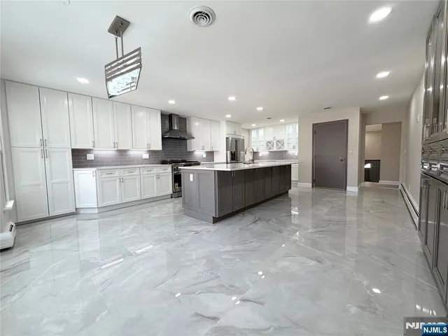 a large kitchen with kitchen island a sink stainless steel appliances and a counter top