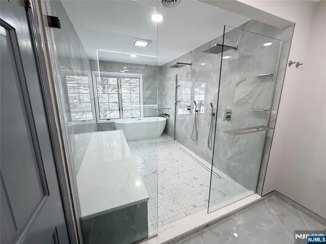 a large white bathroom with a glass shower door