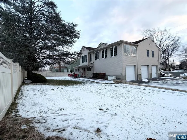a view of a white house with a yard covered in snow