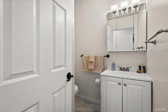 a bathroom with a sink a toilet and vanity