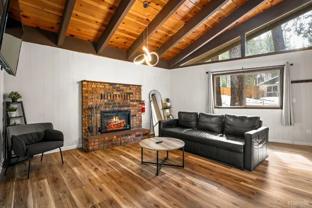 a living room with furniture a fireplace and a large window