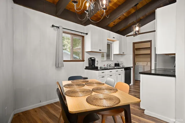 a kitchen with stainless steel appliances granite countertop a sink a stove a refrigerator with a dining table and chairs