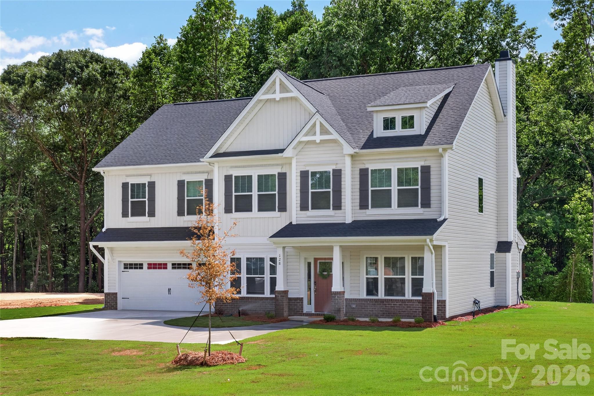 128 Overcash Road, Unit 7171 Troutman, NC 28166 - Photo 3 of 41 a view of a white house with a big yard and potted plants