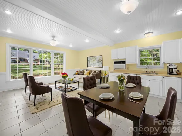 a kitchen with stainless steel appliances granite countertop a stove top oven a sink dishwasher and white cabinets with wooden floor