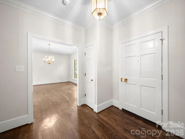 a dining room with furniture a chandelier and wooden floor