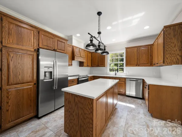 a kitchen with a stove a sink dishwasher a kitchen island with wooden cabinets and floor
