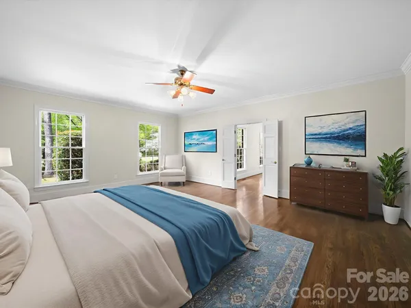 a spacious bedroom with a large bed and a chandelier