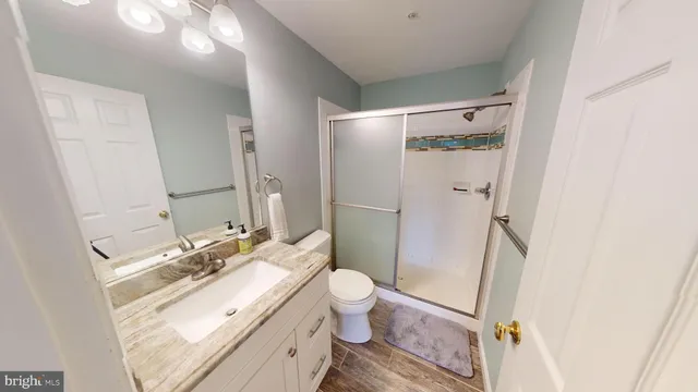 a bathroom with a double vanity sink toilet mirror and shower
