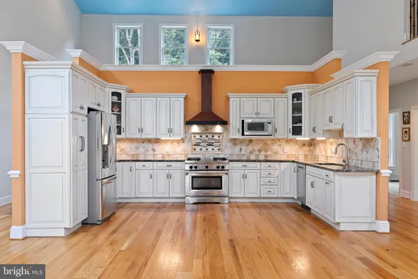 a kitchen with stainless steel appliances a stove top oven and a refrigerator