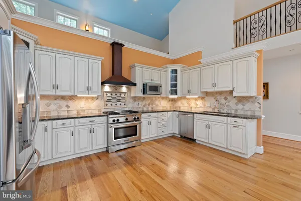 a kitchen with granite countertop a stove top oven sink and cabinets