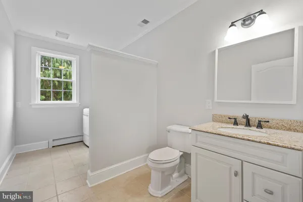 a bathroom with a granite countertop sink a toilet and a mirror
