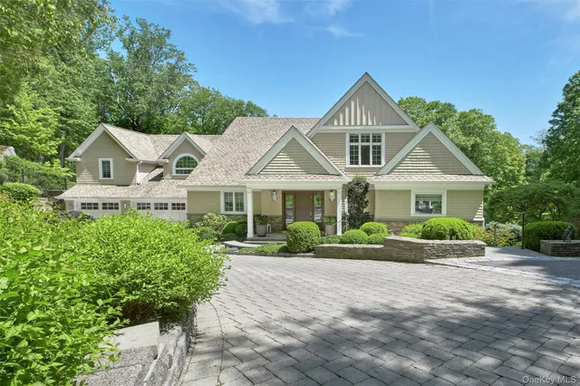 a front view of a house with a yard and potted plants