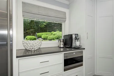a kitchen with granite countertop white cabinets and stainless steel appliances