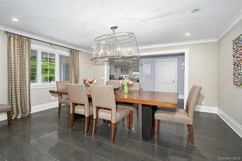 a view of a dining room with furniture a chandelier and wooden floor