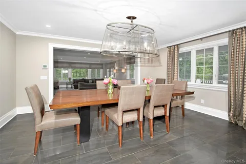 a dining room with wooden floor a chandelier a wooden table and chairs