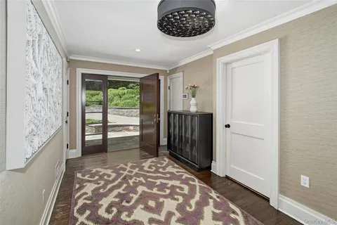 a view of a hallway with wooden floor and a bedroom