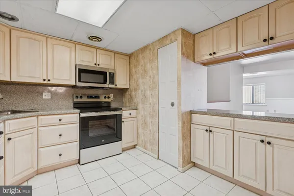 a kitchen with white cabinets and appliances