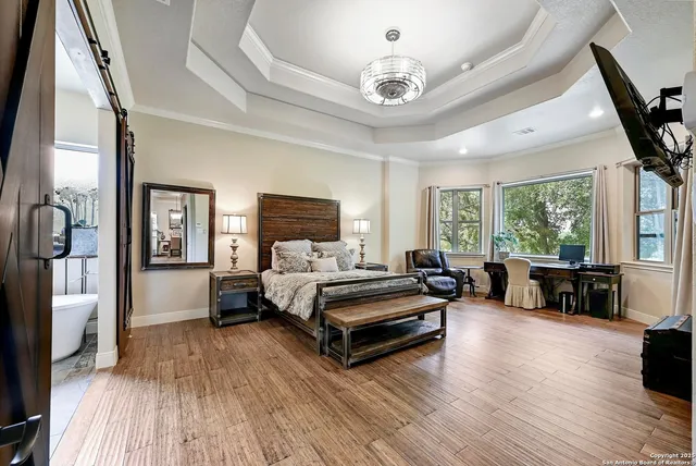 a spacious bedroom with a bed and a chandelier