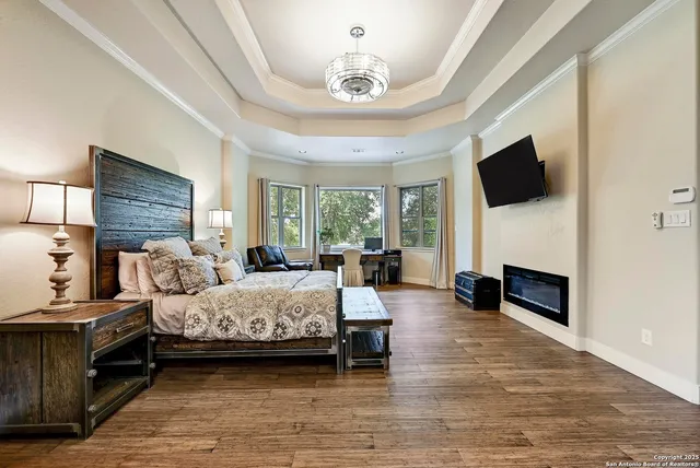 a bedroom with a bed a flat screen tv and a fireplace
