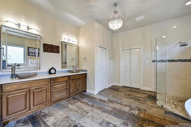 a spacious bathroom with a double vanity sink a mirror and shower