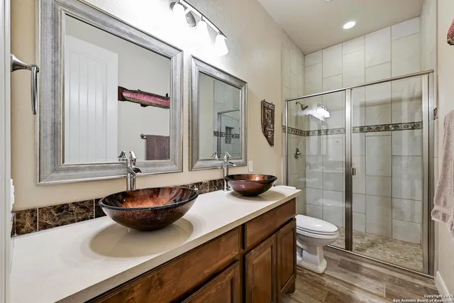 a bathroom with a sink a toilet and shower