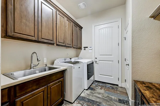a utility room with a sink washer and dryer