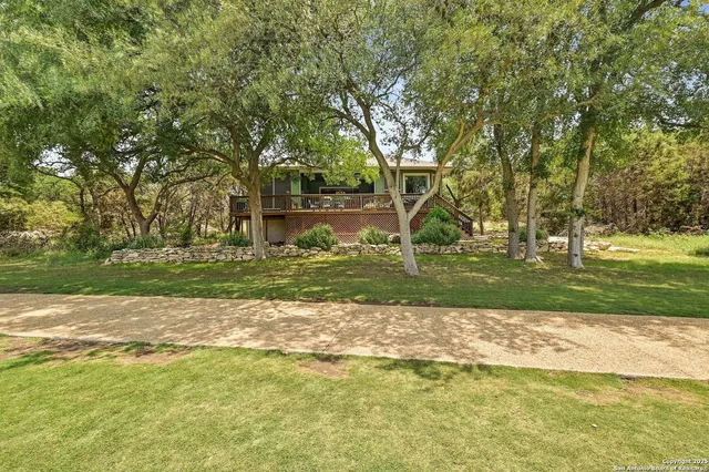 a view of a golf ground with large trees