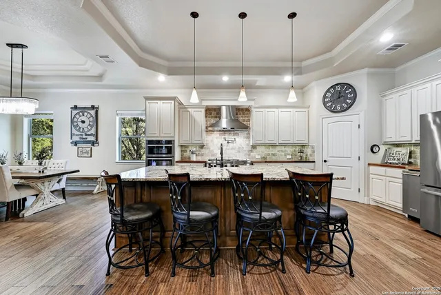 a kitchen with stainless steel appliances kitchen island a table and chairs in it