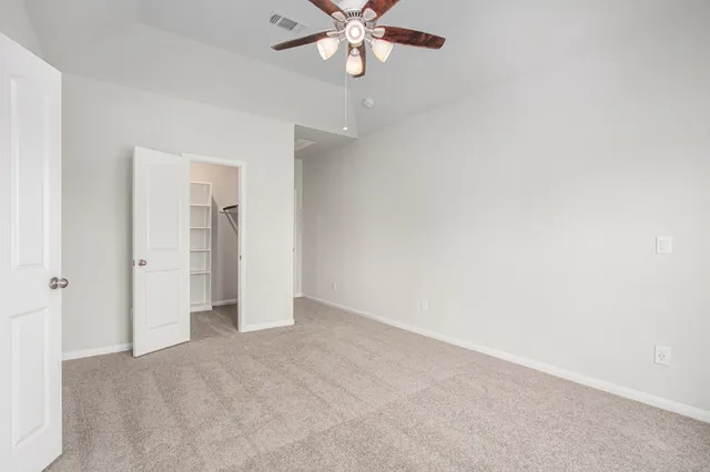 a view of an empty room with a ceiling fan