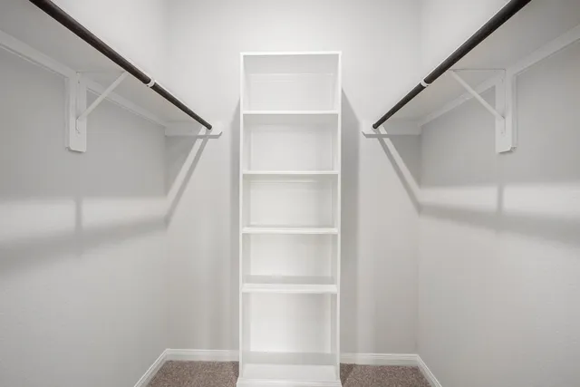 a view of walk in closet with empty racks