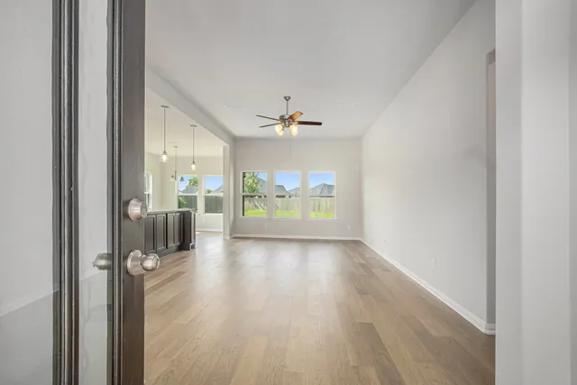 a view of a hallway with a glass door and chandelier