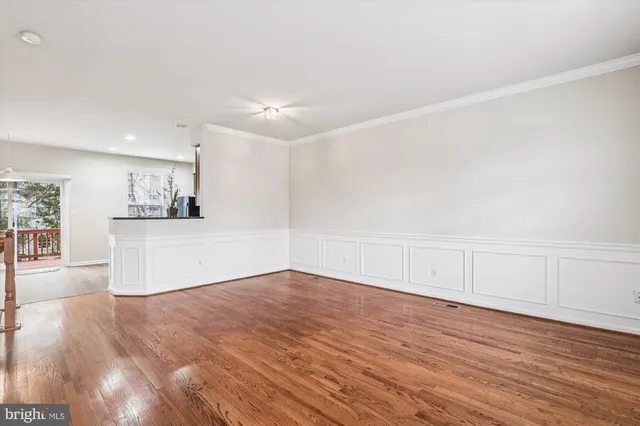 a view of empty room with wooden floor and window