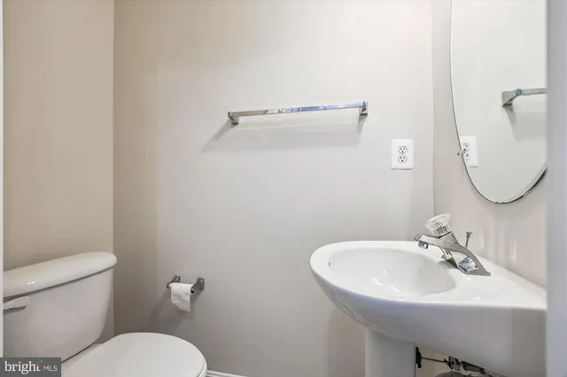 a bathroom with a sink mirror and toilet