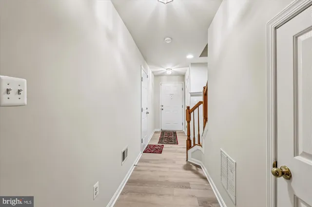 a view of a hallway with wooden floor and staircase