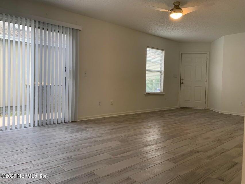 5653 Ellis Trace Drive Jacksonville, FL 32205 - Photo 2 of 12 an empty room with wooden floor and windows