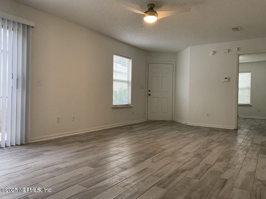 5653 Ellis Trace Drive Jacksonville, FL 32205 - Photo 5 of 12 a view of an empty room with window and wooden floor