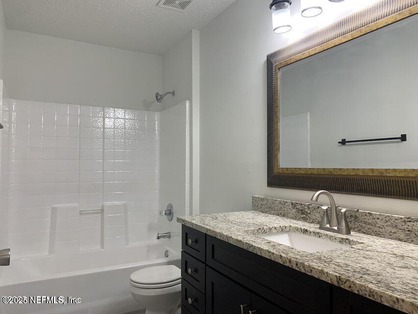 5653 Ellis Trace Drive Jacksonville, FL 32205 - Photo 10 of 12 a bathroom with a granite countertop sink toilet mirror and shower