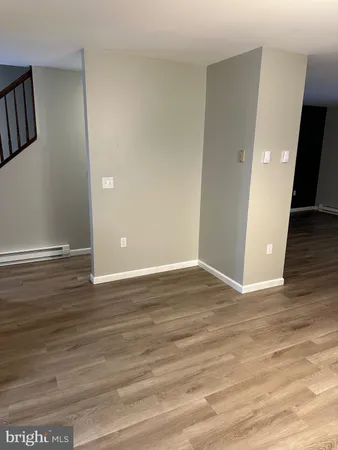 a view of an empty room with wooden floor and closet