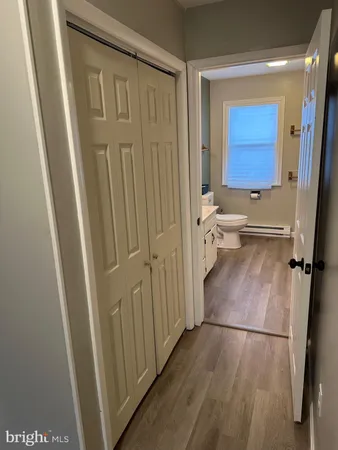 an empty room with wooden floor chandelier fan and windows