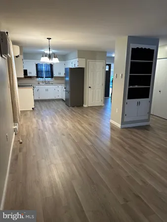 a view of a kitchen with wooden floor and electronic appliances