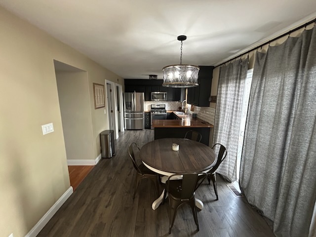 29 Ivanhoe Lane Cary, IL 60013 - Photo 14 of 36 a dining room with furniture a chandelier and wooden floor