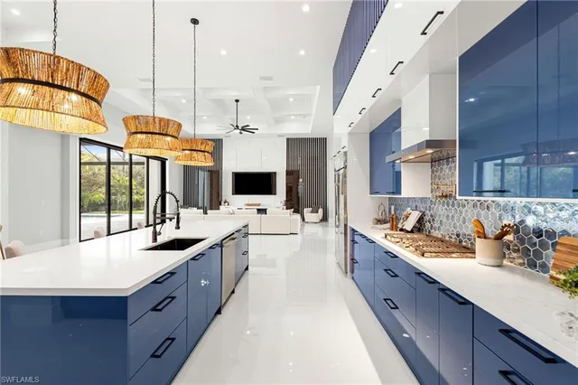 a large kitchen with stainless steel appliances kitchen island granite countertop a sink counter space and a view of living room