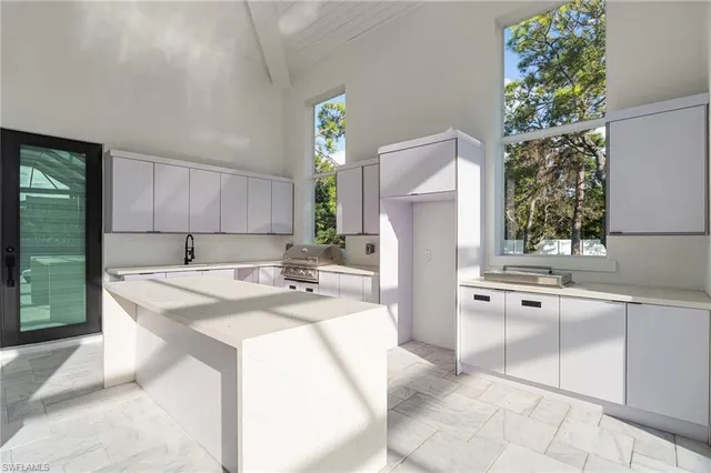 a kitchen with kitchen island granite countertop a sink a stove a refrigerator and island