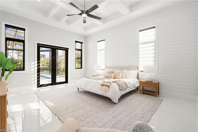 a spacious bedroom with a large bed and a chandelier