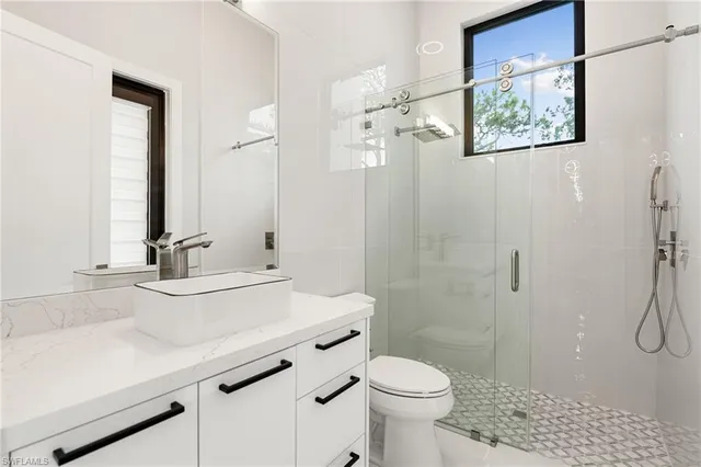 a bathroom with a sink a toilet and shower